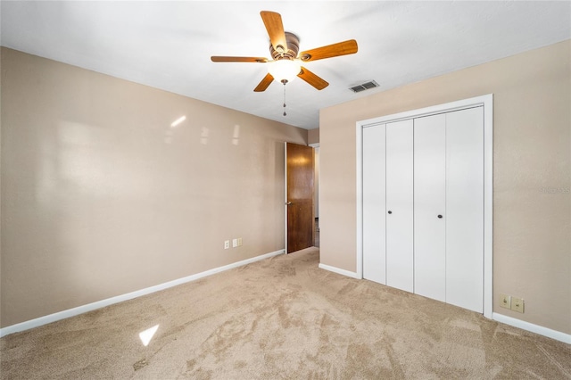 unfurnished bedroom with carpet, ceiling fan, and a closet