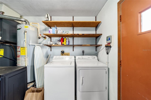 washroom featuring water heater and washing machine and clothes dryer