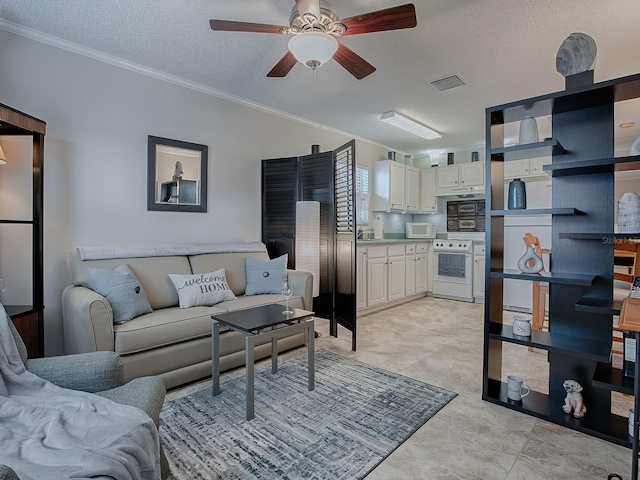 living room featuring ceiling fan, a textured ceiling, and ornamental molding