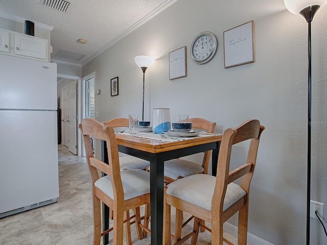 dining room with ornamental molding and a textured ceiling