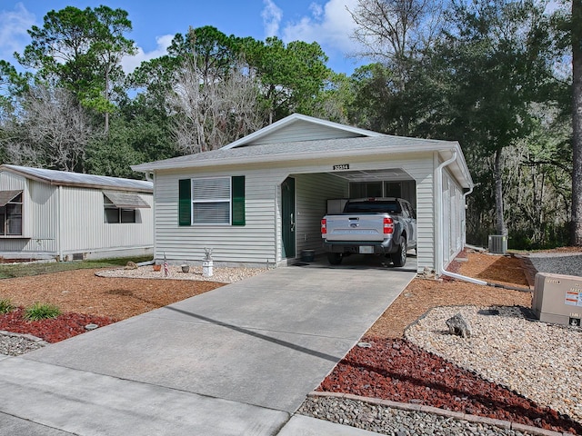 view of front of house with a carport and central AC