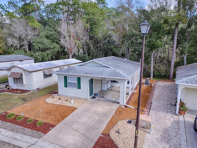 view of front of property featuring central AC unit and a carport