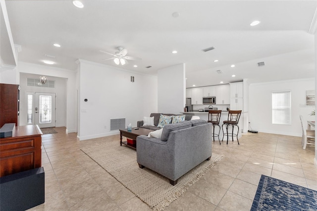 living room with ceiling fan, plenty of natural light, light tile patterned flooring, and crown molding