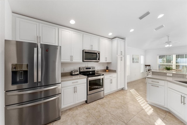 kitchen featuring white cabinets, stainless steel appliances, and ornamental molding