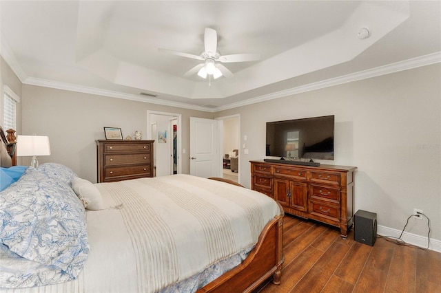 bedroom with ceiling fan, ornamental molding, dark hardwood / wood-style flooring, and a tray ceiling