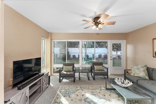 carpeted living room with ceiling fan and a wealth of natural light