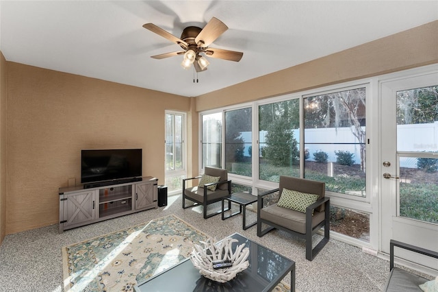 living room with ceiling fan, a wealth of natural light, and carpet flooring