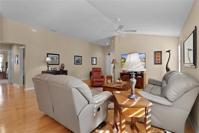 living room with ceiling fan, light hardwood / wood-style flooring, and vaulted ceiling