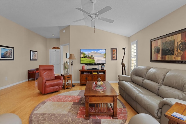 living room with ceiling fan, vaulted ceiling, and light wood-type flooring