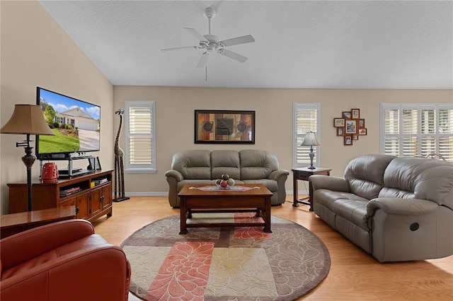 living room with ceiling fan, plenty of natural light, and light wood-type flooring