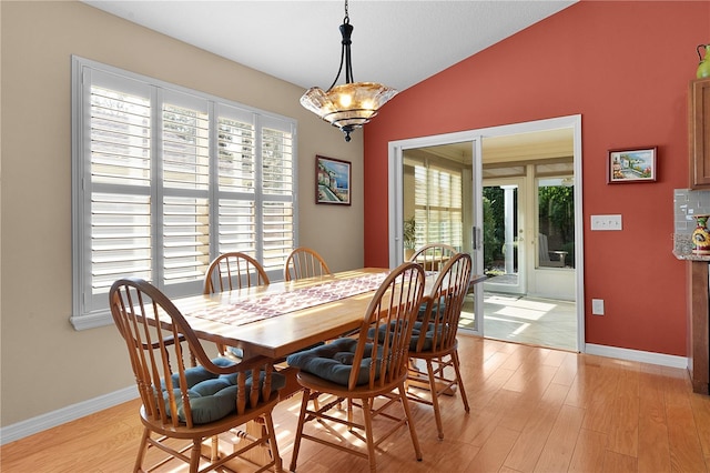 dining room with light hardwood / wood-style flooring, a healthy amount of sunlight, and lofted ceiling