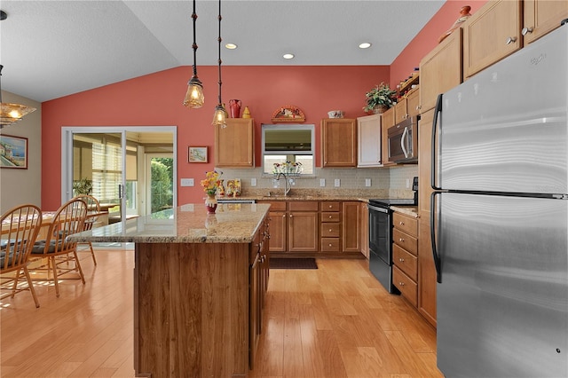 kitchen with lofted ceiling, light hardwood / wood-style flooring, tasteful backsplash, decorative light fixtures, and stainless steel appliances