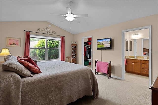 bedroom with lofted ceiling, a walk in closet, ceiling fan, connected bathroom, and a closet