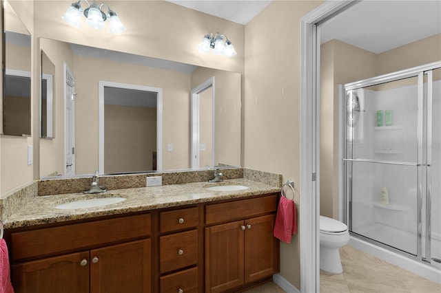 bathroom featuring tile patterned flooring, vanity, toilet, and a shower with door