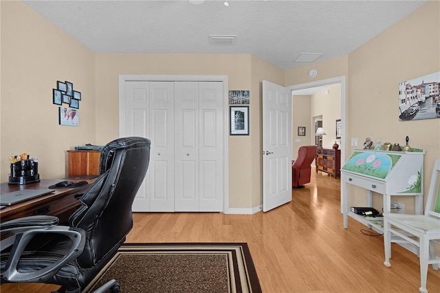 home office featuring a textured ceiling and light wood-type flooring