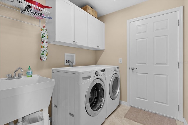 washroom with washer and clothes dryer, light tile patterned flooring, cabinets, and sink