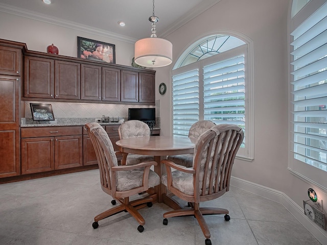 dining space with light tile patterned floors, ornamental molding, and baseboards