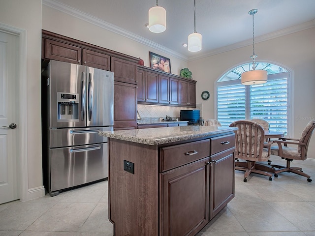 kitchen featuring stainless steel fridge, a kitchen island, backsplash, and decorative light fixtures