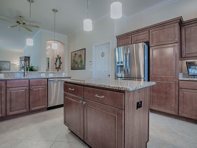 kitchen with stainless steel appliances, ornamental molding, a sink, and light stone countertops