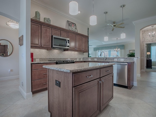 kitchen with a center island, arched walkways, crown molding, stainless steel appliances, and a peninsula