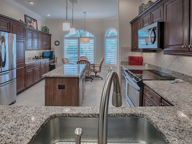 kitchen featuring light stone counters, a center island, crown molding, stainless steel appliances, and a sink