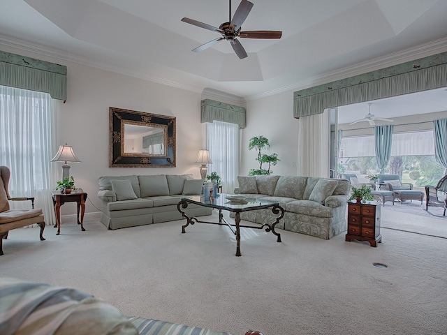 carpeted living room featuring ceiling fan, crown molding, and a tray ceiling