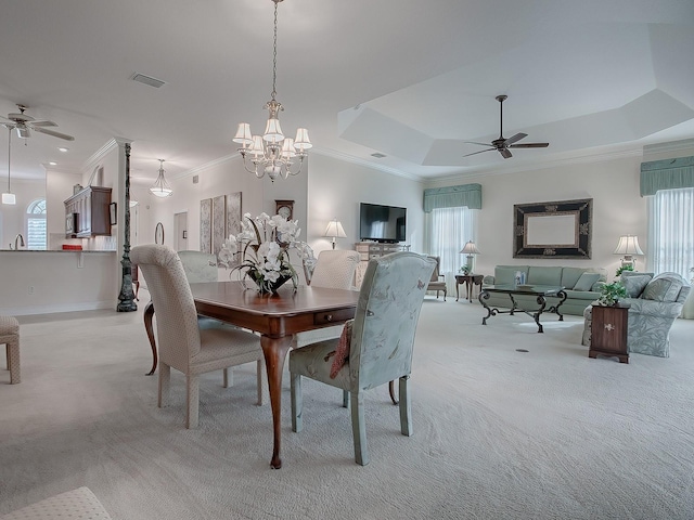 dining space featuring plenty of natural light, a raised ceiling, light carpet, and crown molding