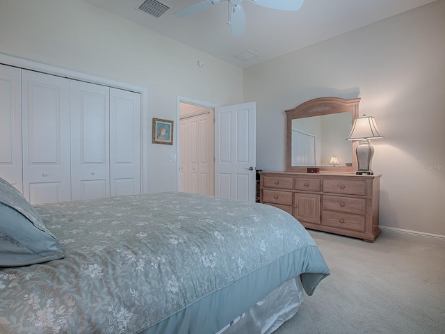 bedroom with ceiling fan, light carpet, visible vents, baseboards, and two closets