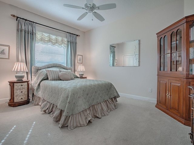 carpeted bedroom with ceiling fan and baseboards