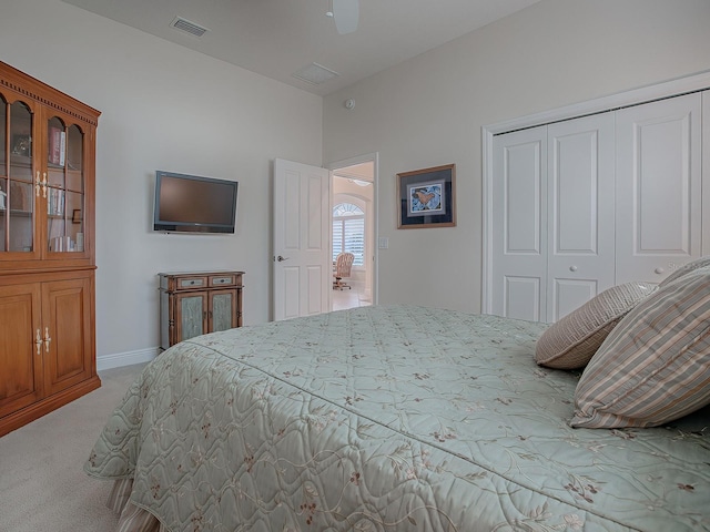 bedroom featuring ceiling fan, light carpet, and a closet