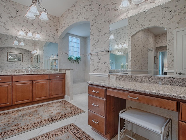 bathroom with two vanities, a walk in shower, a chandelier, tile patterned flooring, and wallpapered walls