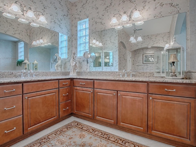 bathroom with double vanity, wallpapered walls, tile patterned flooring, and a sink