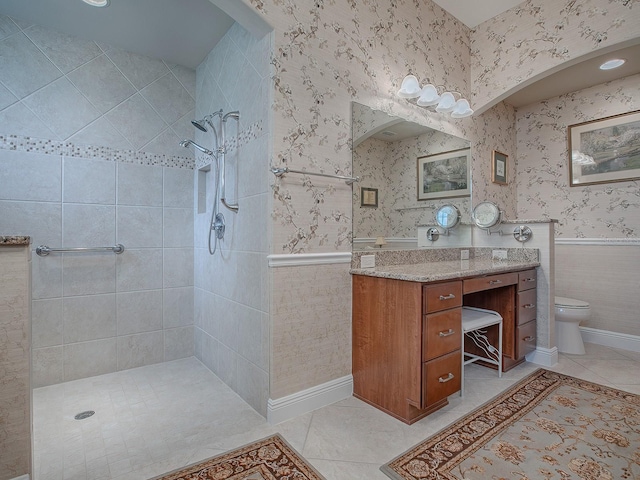 full bathroom featuring wallpapered walls, tile patterned flooring, a walk in shower, and wainscoting