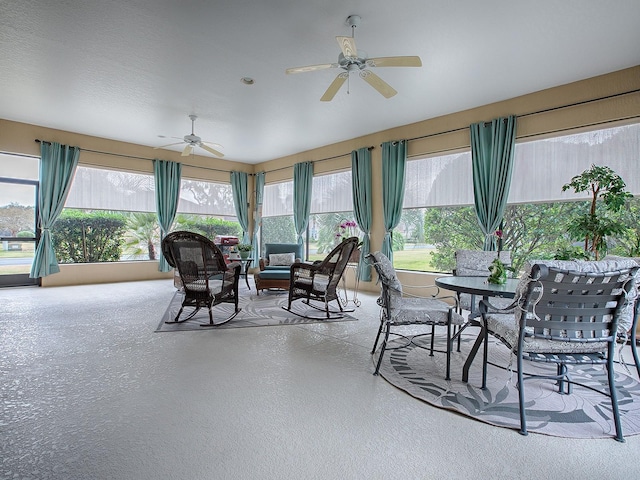 sunroom / solarium featuring a ceiling fan