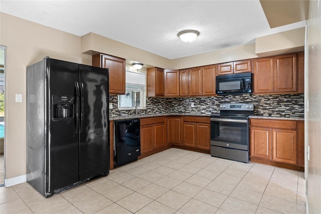 kitchen featuring plenty of natural light, light tile patterned floors, and black appliances