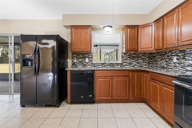 kitchen with black appliances, sink, decorative backsplash, light tile patterned flooring, and light stone counters