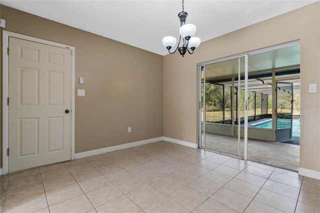 tiled spare room with an inviting chandelier