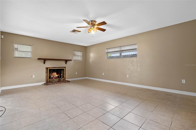 unfurnished living room featuring a fireplace, ceiling fan, and light tile patterned flooring