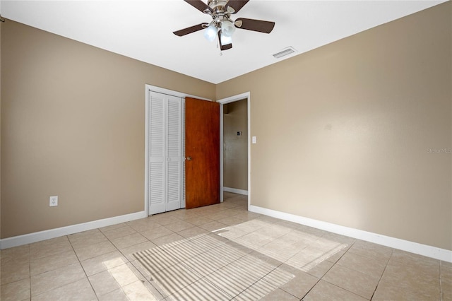 unfurnished bedroom featuring ceiling fan, a closet, and light tile patterned flooring