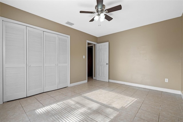 unfurnished bedroom featuring ceiling fan, light tile patterned flooring, and a closet