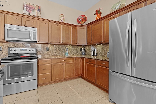 kitchen with light tile patterned floors, light stone countertops, appliances with stainless steel finishes, and tasteful backsplash