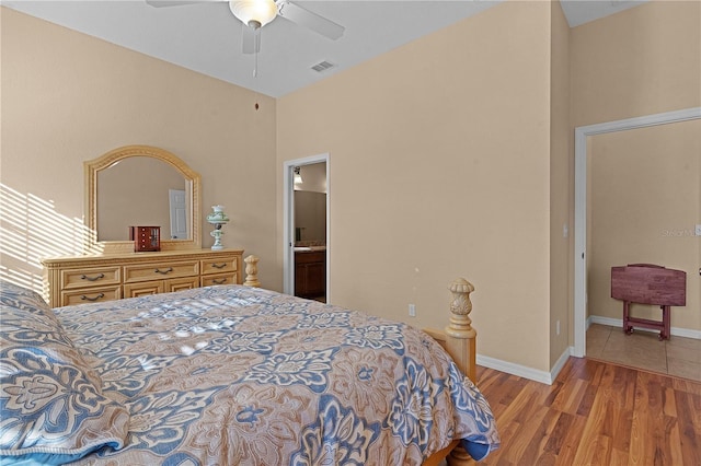 bedroom with ensuite bathroom, ceiling fan, and light hardwood / wood-style floors