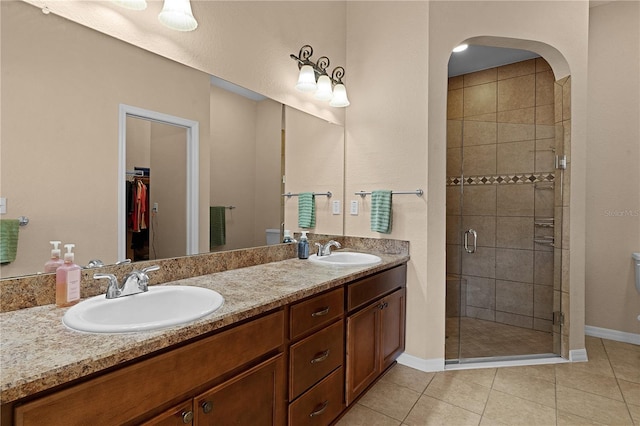 bathroom featuring tile patterned flooring, vanity, and an enclosed shower