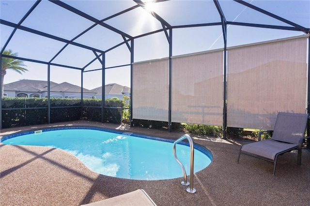 view of pool featuring glass enclosure and a patio area