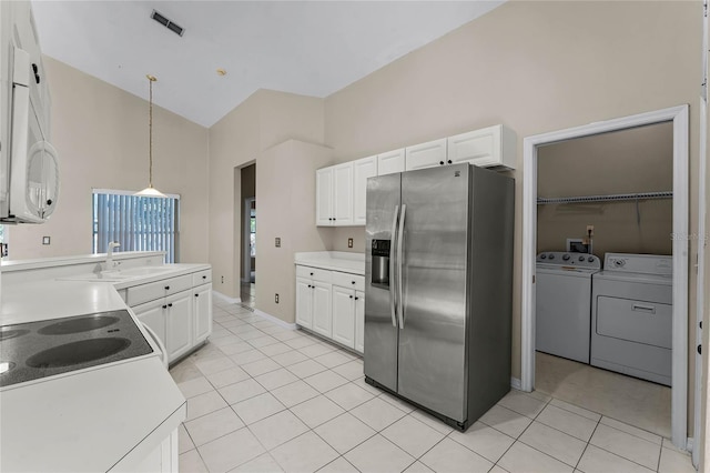 kitchen featuring white cabinetry, sink, stainless steel fridge with ice dispenser, decorative light fixtures, and washer and clothes dryer