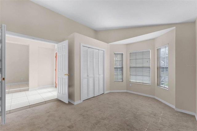 unfurnished bedroom with light carpet and lofted ceiling