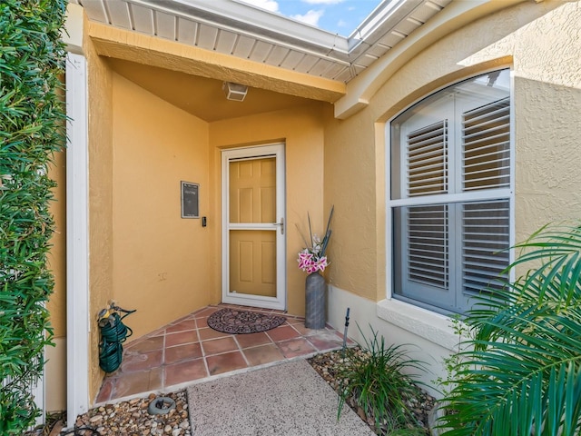 doorway to property featuring stucco siding