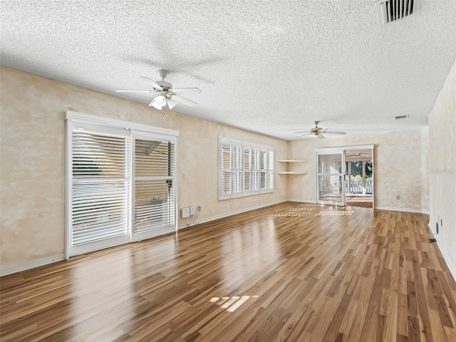 unfurnished living room with ceiling fan, wood-type flooring, and a textured ceiling