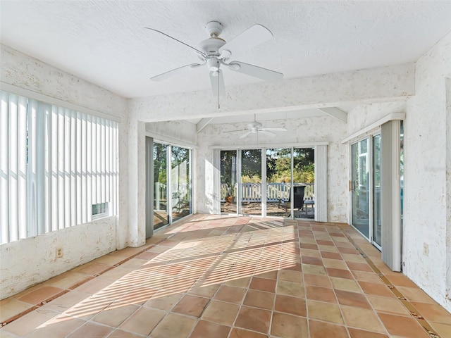 unfurnished sunroom featuring ceiling fan and beamed ceiling