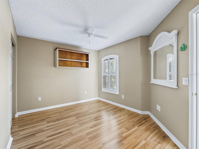 spare room featuring a textured ceiling, light hardwood / wood-style floors, and ceiling fan